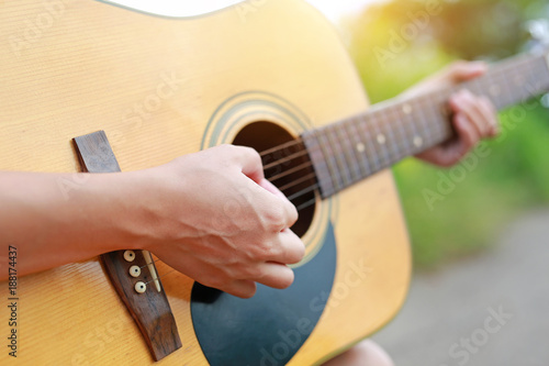 Fotografía Close-up male hands playing on acoustic guitar in the nature.