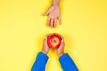 Kid Hand Taking Red Apple From Another Child's Hands
