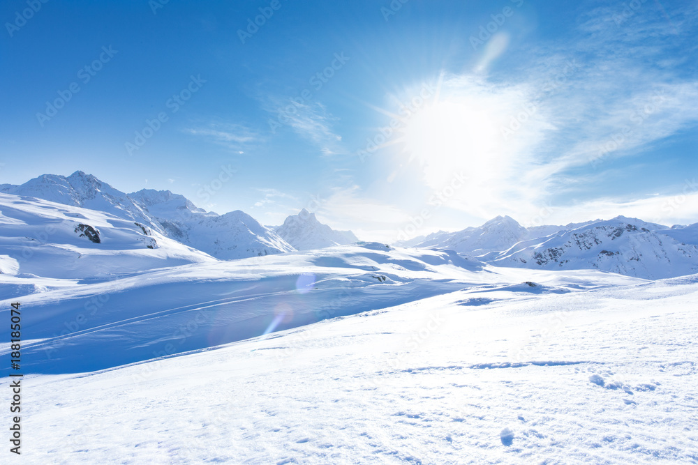 Junge sportliche Frau fährt Ski, macht Winter Sport in einem Winter Paradis. Schnee bedeckte Berge, blauer Himmel und Farbenfroher Ski Anzug - obrazy, fototapety, plakaty 