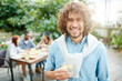 © pressmaster - Happy guy with toothy smile holding glass of fresh homemade lemonade