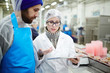 © pressmaster - Colleagues from seafood processing plant discussing online data about canned food