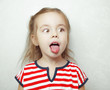 © Ilshat - Adorablr little girl pulls her tongue out and looks sideways