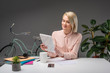 © LIGHTFIELD STUDIOS - beautiful young businesswoman using tablet at workplace isolated on grey