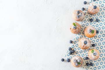 Wall Mural - Blueberries muffins or cupcakes with mint leaves on white texture
