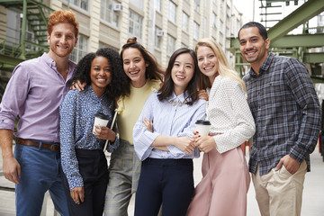 Wall Mural - Six young adult coworkers standing outdoors, group portrait