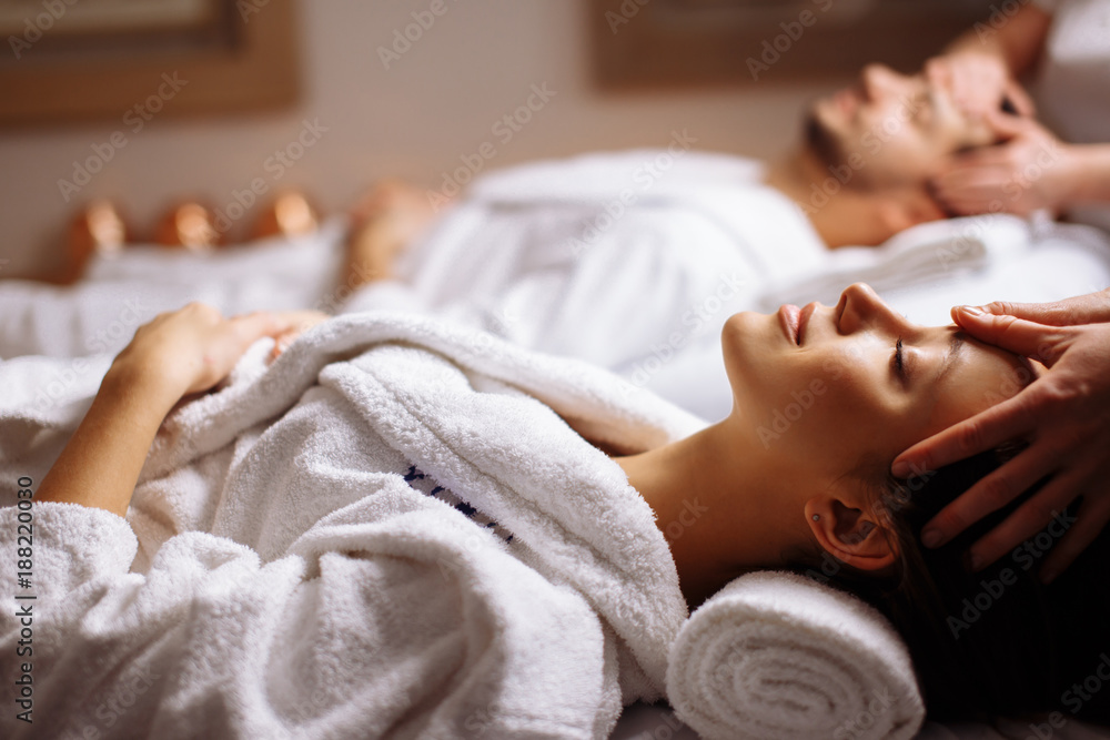 Young couple receiving head massage at beauty spa - obrazy, fototapety, plakaty 