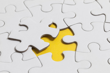 White jigsaw puzzle pieces on a yellow background. Business solution concept