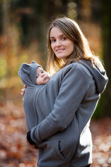 Poster - Mother, carrying her baby boy in a sling, outdoors