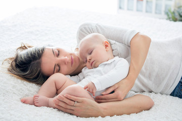 Sticker - Mother and her baby son, sleeping on a big bed, soft back light