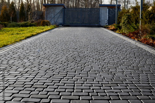 Cuadros en Lienzo Cobblestone entrance in the garden, graphite paving stone texture, pavement