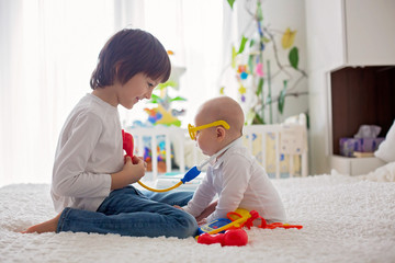 Wall Mural - Little toddler boy, playing with his little brother at home