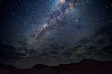 Wall Mural - milky way arch, stars in the sky, the namib desert in namibia, africa. some scenic clouds.