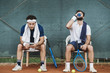 © Arno Images - Two young men having a break after a tennis match on a clay court