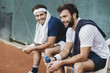 © Arno Images - Two young men having a break after a tennis match on a clay court