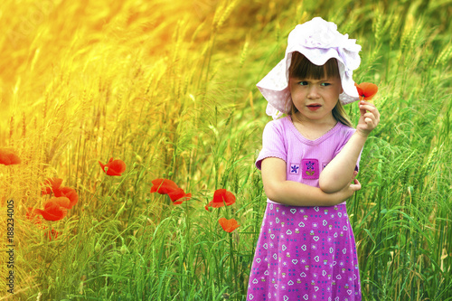 Valokuva Little displeased and dissatisfied cute girl with red flower