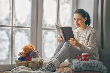 Wall Mural - woman sitting by the window