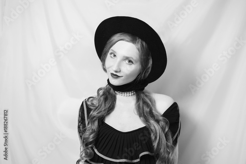 A Woman With A Smirk With Long Red Straight Hair In A Black Hat On A