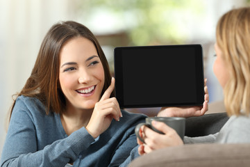 Canvas Print - Girl showing a blank tablet screen to a friend