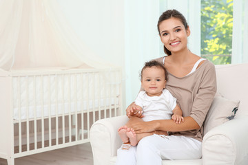 Canvas Print - Mother and cute baby sitting in armchair after bathing at home