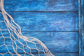 Old blue board with fishing net with copy space