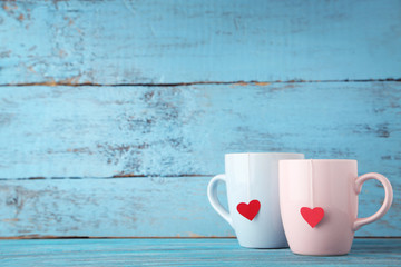 Cups of tea with red heart on wooden table