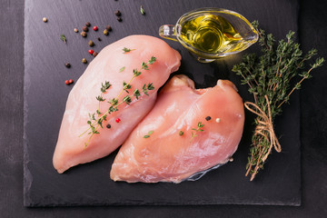 Raw chicken fillets with spices and herbs.