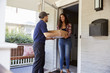 © Monkey Business - Courier Delivering Package To Woman At Home