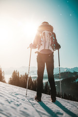 Wall Mural - Female hiker standing against winter mountains