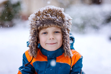 Poster - Happy kid boy having fun with snow in winter