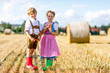 © Irina Schmidt - Two kids, boy and girl in traditional Bavarian costumes in wheat field