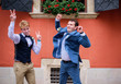 Groom and groomsman have fun on the streets of an old city