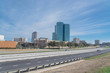 Irving, Texas skyline view from John Carpenter Freeway under winter cloud blue sky. Cityscape and transportation background.