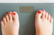 © fotoduets - Woman with barefoot standing on the scales. Cares about a body. Weight loss concept. Top view.
