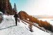 © XtravaganT - Woman hiking along snowy trail in mountains