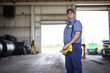 © Cavan Images - Worker holding control machine while standing at metal industry