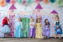 Girls Standing Against Painted Wall At Princess Party