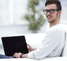 modern young man working on laptop sitting in the living room.