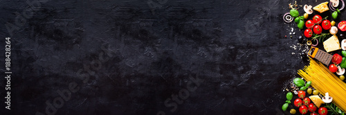 Fotomural Food ingredients for italian pasta, spaghetti on black stone slate background