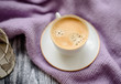 Cup of coffee and sweater on a wooden background