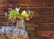 Berry bouquet in a glass on a wooden background
