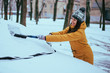 young woman clean car after snow storm
