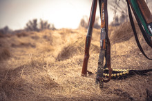 Hunting Scene In Wild West With Hunting Shotguns And Ammunition Belt On Dry Grass In Rural Field During Hunting Season As Hunting Background With Copy Space