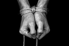 Hands Tied With A Rope Close-up Black Background Monochrome
