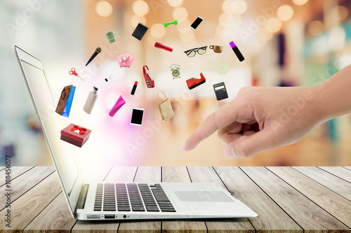 Fotografía Shopping cart and laptop computer with products on wood bokeh background, shop online concept
