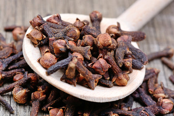 Wall Mural - Cloves in a wooden spoon on table