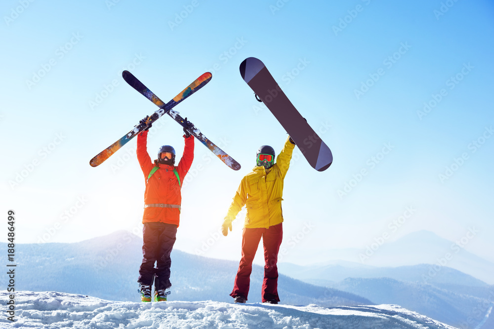 Active skier and snowboarder against mountains - obrazy, fototapety, plakaty 