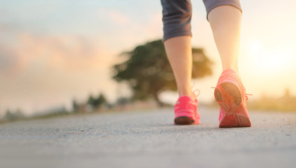 athlete woman walking exercise on rural road in sunset background, healthy and lifestyle concept