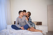 © dmitriisimakov - mom dad and son in the morning lying on the bed at home