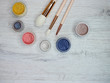 Make up powder and brushes on white wood flat lay color