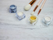 Make up powder and brushes on white wood flat lay color
